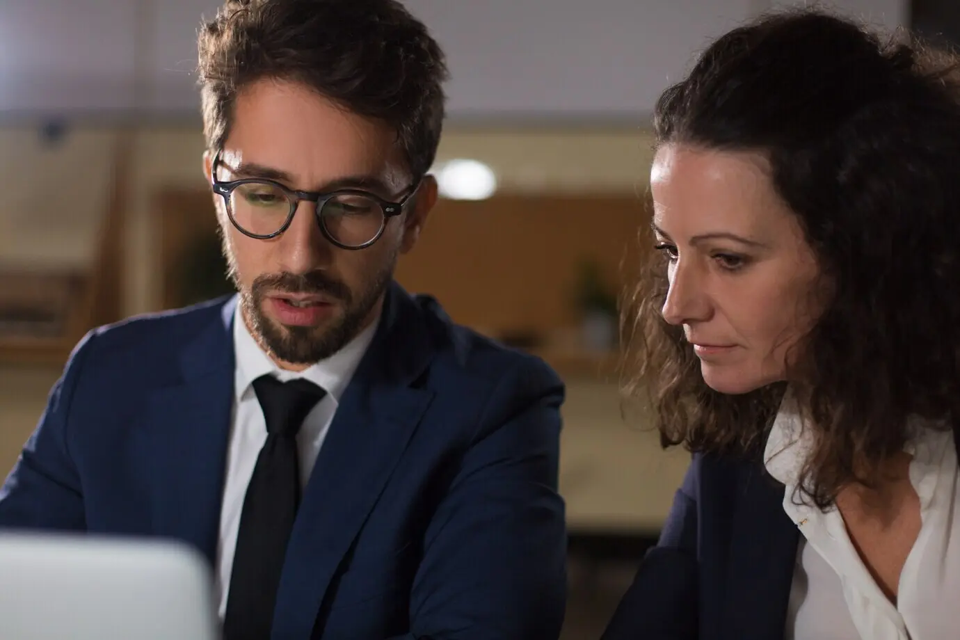 Konzentrierte Geschäftsleute, die mit einem Laptop arbeiten.